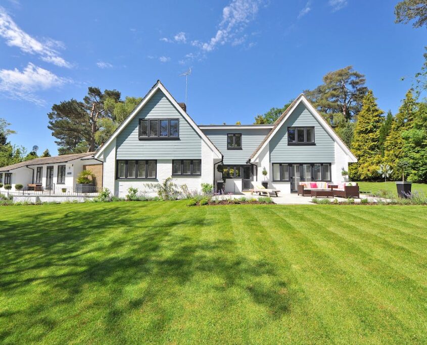 An image of the outside of a large white and grey home